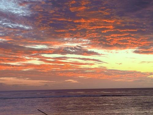 a sunset on the beach with a cloudy sky at Gosun Beach Hotel in Flic-en-Flac