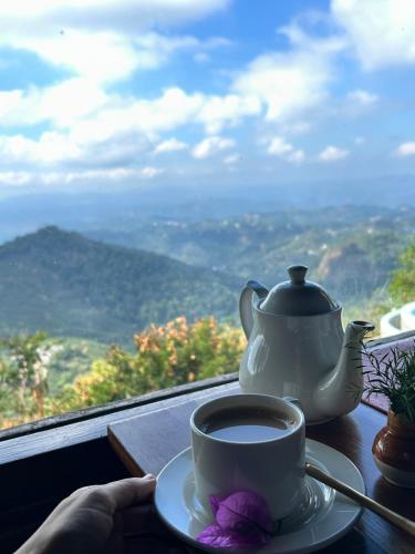 a cup of coffee on a table with a tea pot at Blackberry Hills Munnar Nature Resort & Spa in Munnar