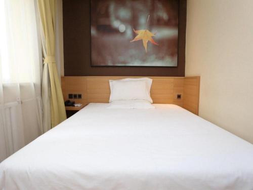 Ένα ή περισσότερα κρεβάτια σε δωμάτιο στο IU Hotel Tianjin Xiqing Zhong Bei Zhen Branch