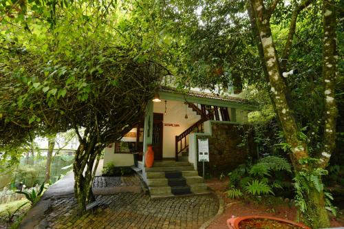 a house with stairs and trees in front of it at Blackberry Hills Munnar Nature Resort & Spa in Munnar