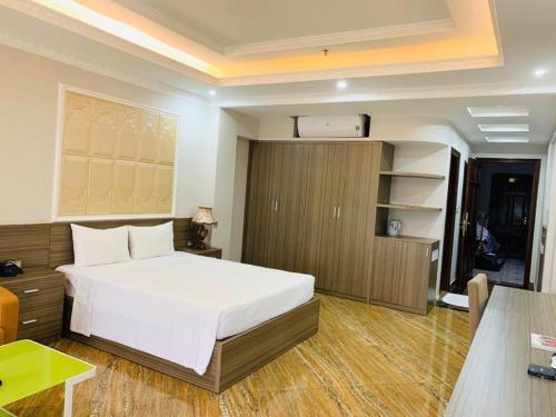 a bedroom with a large white bed and a desk at Bacninh Charming Hotel in Bắc Ninh