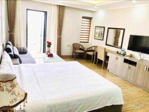 a hotel room with a large bed and a television at Bacninh Charming Hotel in Bắc Ninh