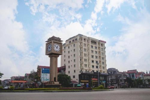 a clock tower in front of a large building at Bacninh Charming Hotel in Bắc Ninh