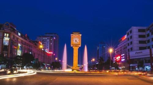 a clock tower in the middle of a city at night at Bacninh Charming Hotel in Bắc Ninh
