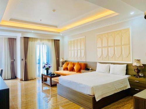 a bedroom with a large bed and a couch at Bacninh Charming Hotel in Bắc Ninh