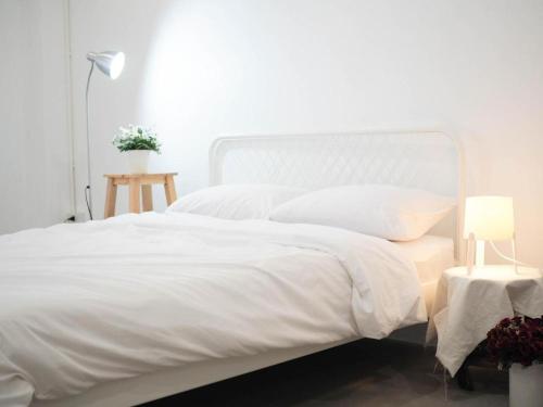 a white bed with white sheets and pillows at Unyak Room Ayutthaya in Phra Nakhon Si Ayutthaya