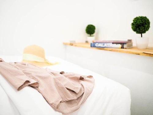 a scarf sitting on a white couch with a shelf at Unyak Room Ayutthaya in Phra Nakhon Si Ayutthaya