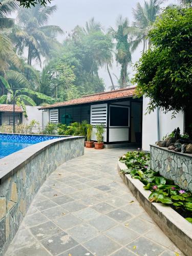 a house with a swimming pool and a garden at Mermaid Island Beach Resorts in Puducherry