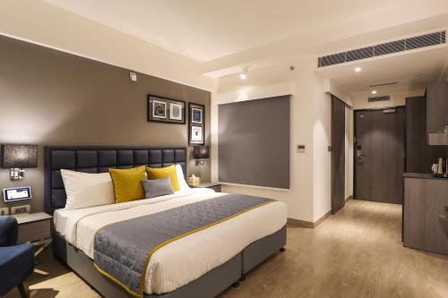 a bedroom with a large bed and a television at AIR by Ahuja Residences in Gurgaon