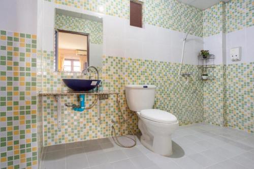 a bathroom with a toilet and a mirror and a sink at OYO 75356 Thipsiri Lodge in Chiang Mai
