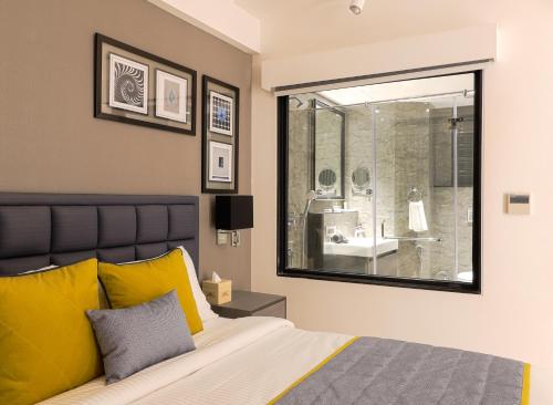 a bedroom with a bed and a large window at AIR by Ahuja Residences in Gurgaon