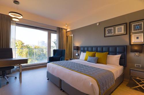 a bedroom with a bed and a desk and a window at AIR by Ahuja Residences in Gurgaon
