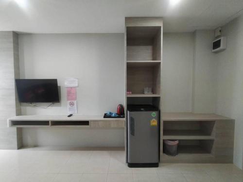 a room with a small refrigerator and a desk at Sattahip 9 Boutique Hotel in Pattaya Central