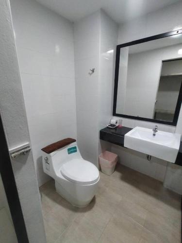 a bathroom with a white toilet and a sink at Sattahip 9 Boutique Hotel in Pattaya Central