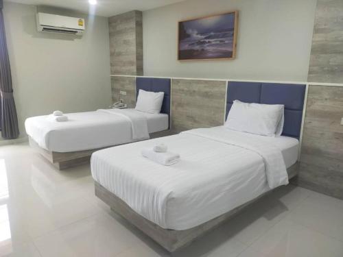 two beds in a room with white and blue at Sattahip 9 Boutique Hotel in Pattaya Central