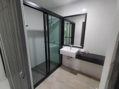a bathroom with a sink and a glass shower at Sattahip 9 Boutique Hotel in Pattaya Central