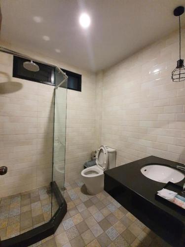 a bathroom with a toilet and a glass shower at THE S VILLAS HOTEL in Nakhon Phanom