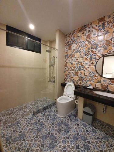a bathroom with a toilet and a glass shower at THE S VILLAS HOTEL in Nakhon Phanom