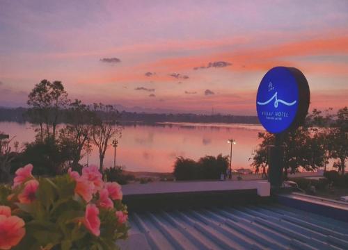 a sign for a swimming pool with a sunset in the background at THE S VILLAS HOTEL in Nakhon Phanom