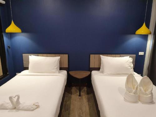two beds in a room with a blue wall at THE S VILLAS HOTEL in Nakhon Phanom