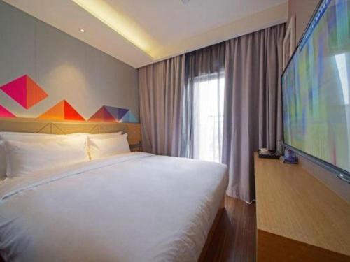 Postel nebo postele na pokoji v ubytování Borrman Hotel Zhaoqing Sihui Tianguangxu Jade City