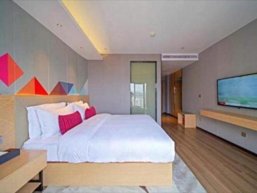 Postel nebo postele na pokoji v ubytování Borrman Hotel Zhaoqing Sihui Tianguangxu Jade City