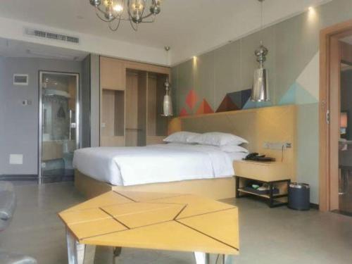 Postel nebo postele na pokoji v ubytování Borrman Hotel Zhaoqing Sihui Tianguangxu Jade City