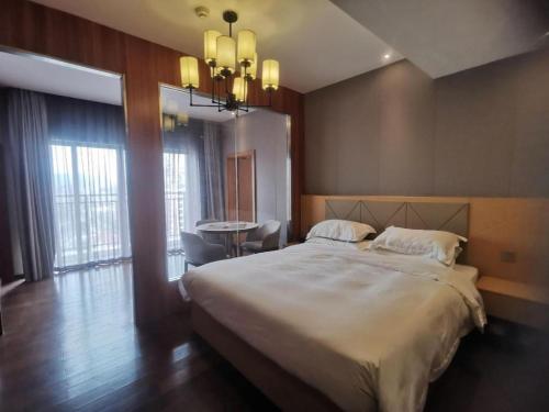 Postel nebo postele na pokoji v ubytování Borrman Hotel Zhaoqing Sihui Tianguangxu Jade City