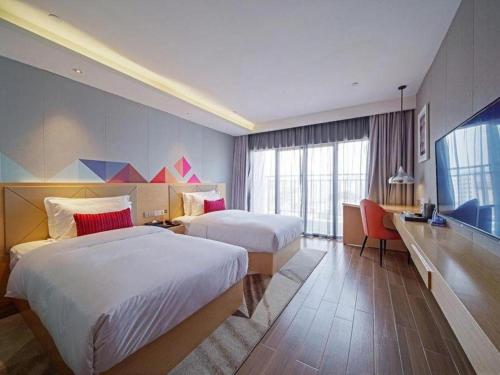 Postel nebo postele na pokoji v ubytování Borrman Hotel Zhaoqing Sihui Tianguangxu Jade City