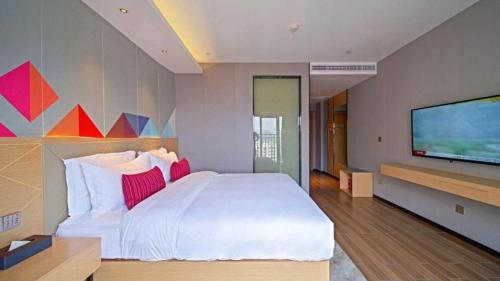 Postel nebo postele na pokoji v ubytování Borrman Hotel Zhaoqing Sihui Tianguangxu Jade City