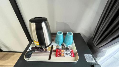 a table with a coffee maker and items on it at The Hub Hotel Surin in Surin