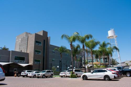 a parking lot with cars parked in front of a building at Hotel Aliana in Salamanca