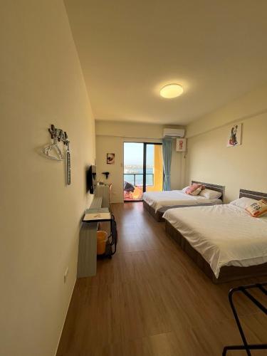 a room with two beds and a desk in it at Shuye Mumu BnB in Magong