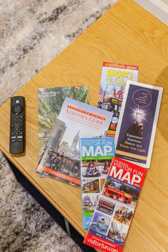 a table with magazines and a remote control on it at Staycation Suite in Philadelphia
