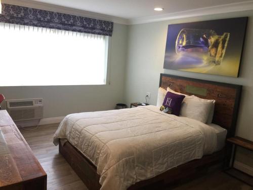 a bedroom with a large bed and a large window at Hotel Solaire Los Angeles in Los Angeles