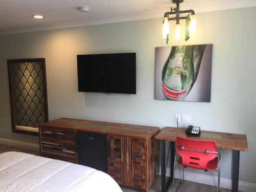 a bedroom with a desk and a tv on the wall at Hotel Solaire Los Angeles in Los Angeles