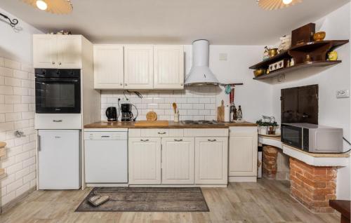 a kitchen with white appliances and white cabinets at Awesome Home In Lopar With Wifi in Lopar