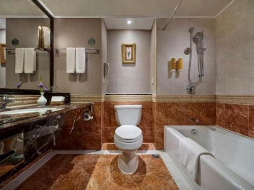 a bathroom with a toilet and a bath tub at New Century Hotel Taizhou 