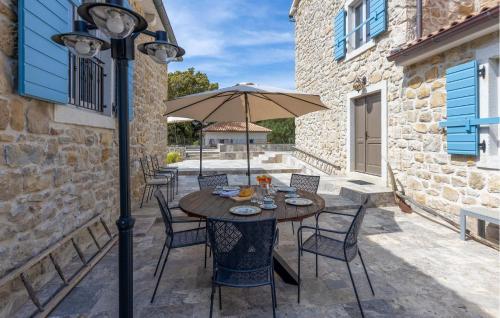 Una mesa y sillas con una sombrilla en un patio. en Amazing Home In Mundanije, en Mundanije