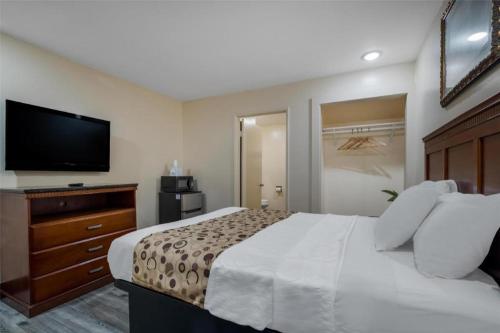 a hotel room with a bed and a flat screen tv at Americas Best Value Inn Redlands San Bernardino in Redlands