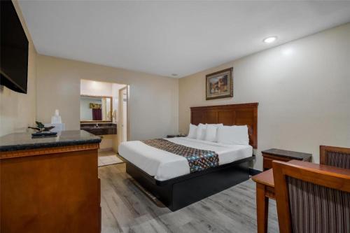 a hotel room with a bed and a desk at Americas Best Value Inn Redlands San Bernardino in Redlands