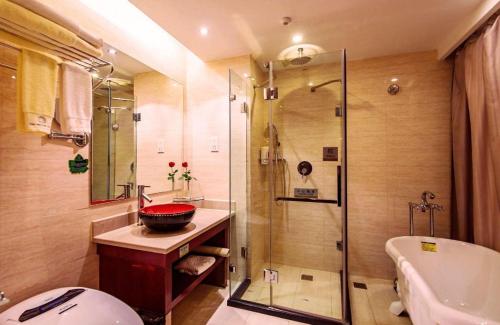a bathroom with a shower and a sink and a tub at New Friendship Hotel in Luoyang