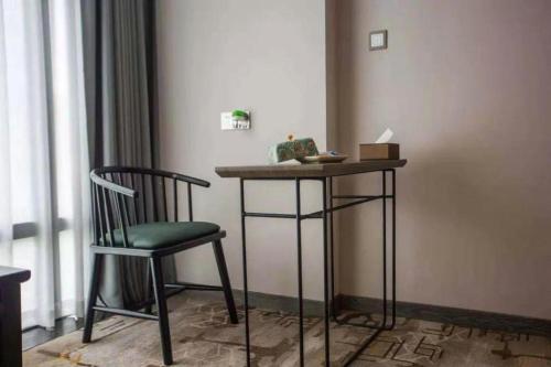 a table and a chair in a room at New Friendship Hotel in Luoyang