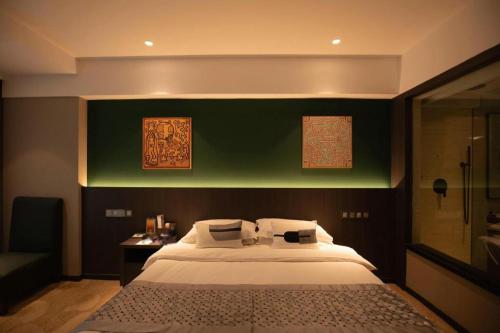 a bedroom with a large bed and a green wall at New Friendship Hotel in Luoyang