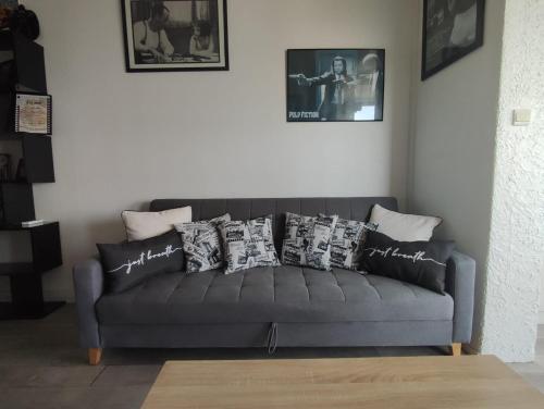 - un canapé dans le salon avec des oreillers dans l'établissement Clap de Soleil Studio Vue Mer, Clim, Fibre, Idéal 2 Pers, à La Ciotat