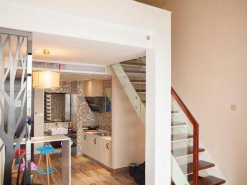 a staircase leading to a kitchen and a living room at Jinjiang Metropolo Hotel - Liyang Tianmu Lake in Liyang