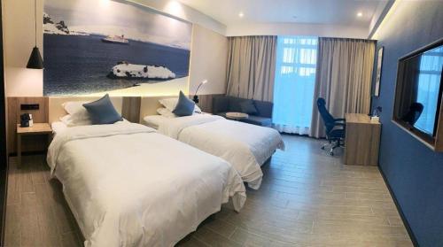 a hotel room with two beds and a painting on the wall at hailihotel in Dongguan