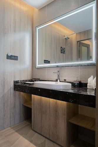 a bathroom with a sink and a large mirror at hailihotel in Dongguan