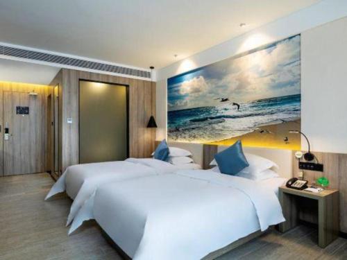 a bedroom with two beds and a painting on the wall at hailihotel in Dongguan