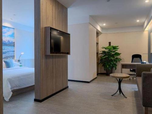 a hotel room with a bed and a flat screen tv at hailihotel in Dongguan